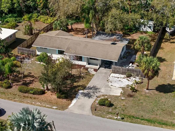 an aerial view of a house with a yard and mountain view in back