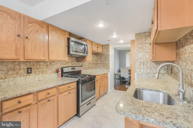 a kitchen with stainless steel appliances granite countertop a sink stove and cabinets