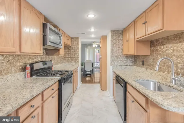 a kitchen with stainless steel appliances granite countertop a sink stove and cabinets