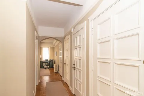 a view of a hallway with a livingroom and a livingroom with furniture