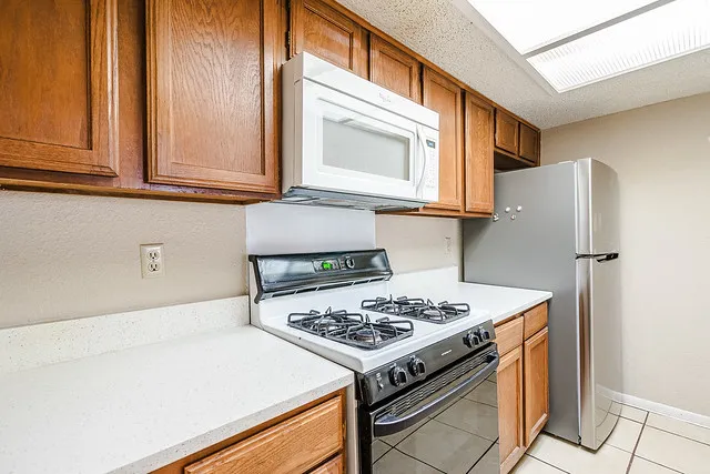 a kitchen with stainless steel appliances granite countertop a stove a refrigerator and a cabinets