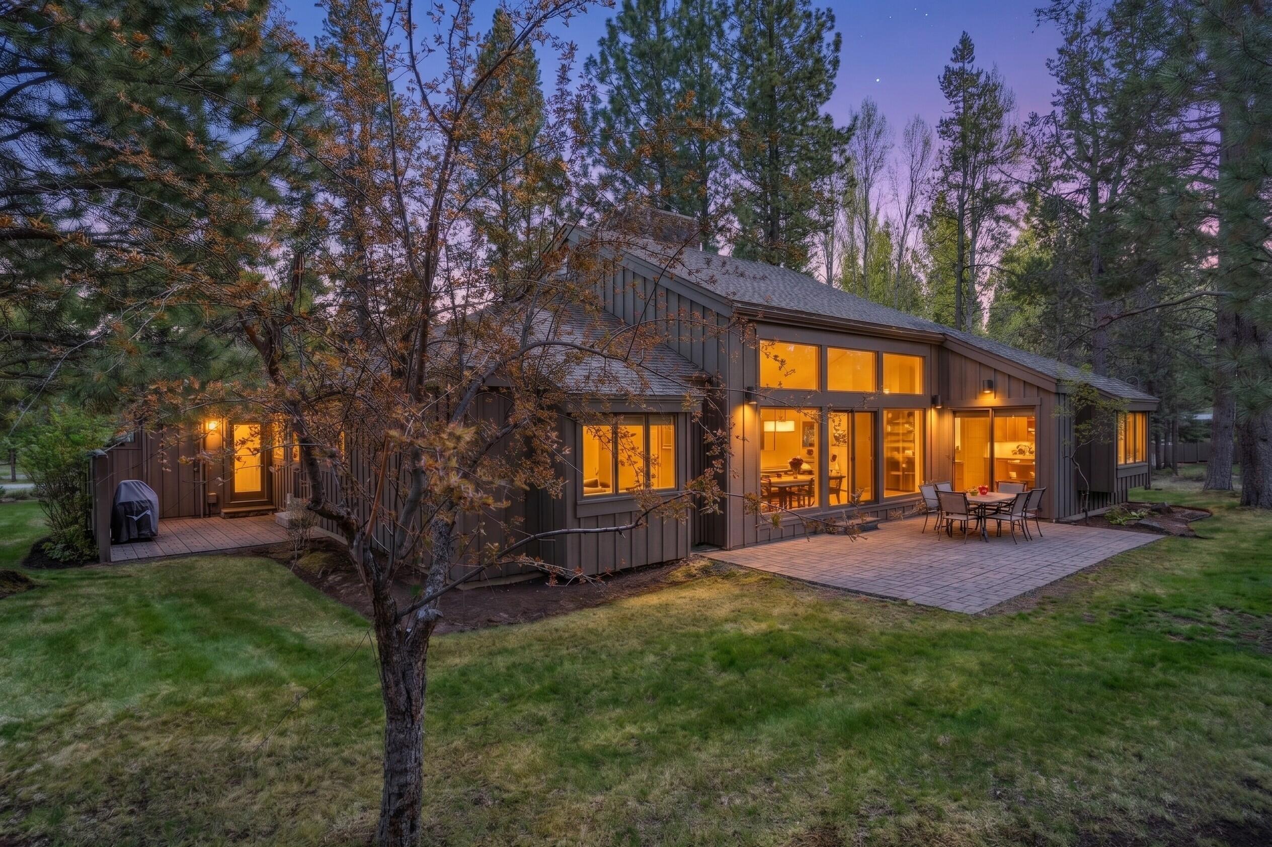 17866 Grouse Lane, Unit 3 Sunriver, OR 97707 - Photo 4 of 61 a view of a backyard with table and chairs and a large tree