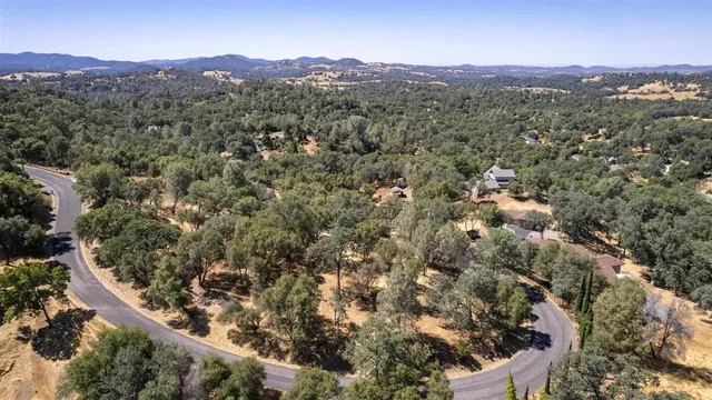 an aerial view of residential house with green space and mountain view