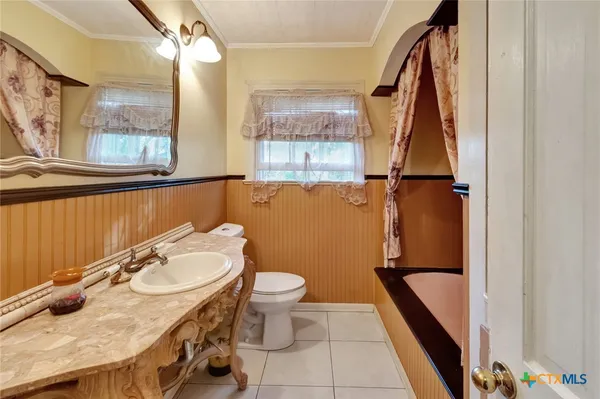 a bathroom with a granite countertop sink toilet and a mirror