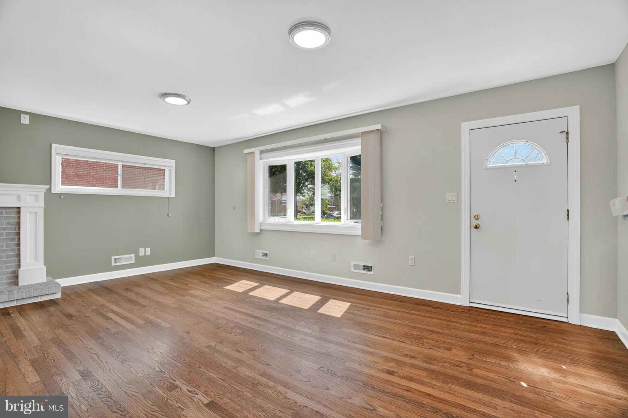 920 Vanderwood Road Catonsville, MD 21228 - Photo 2 of 25 an empty room with wooden floor and windows