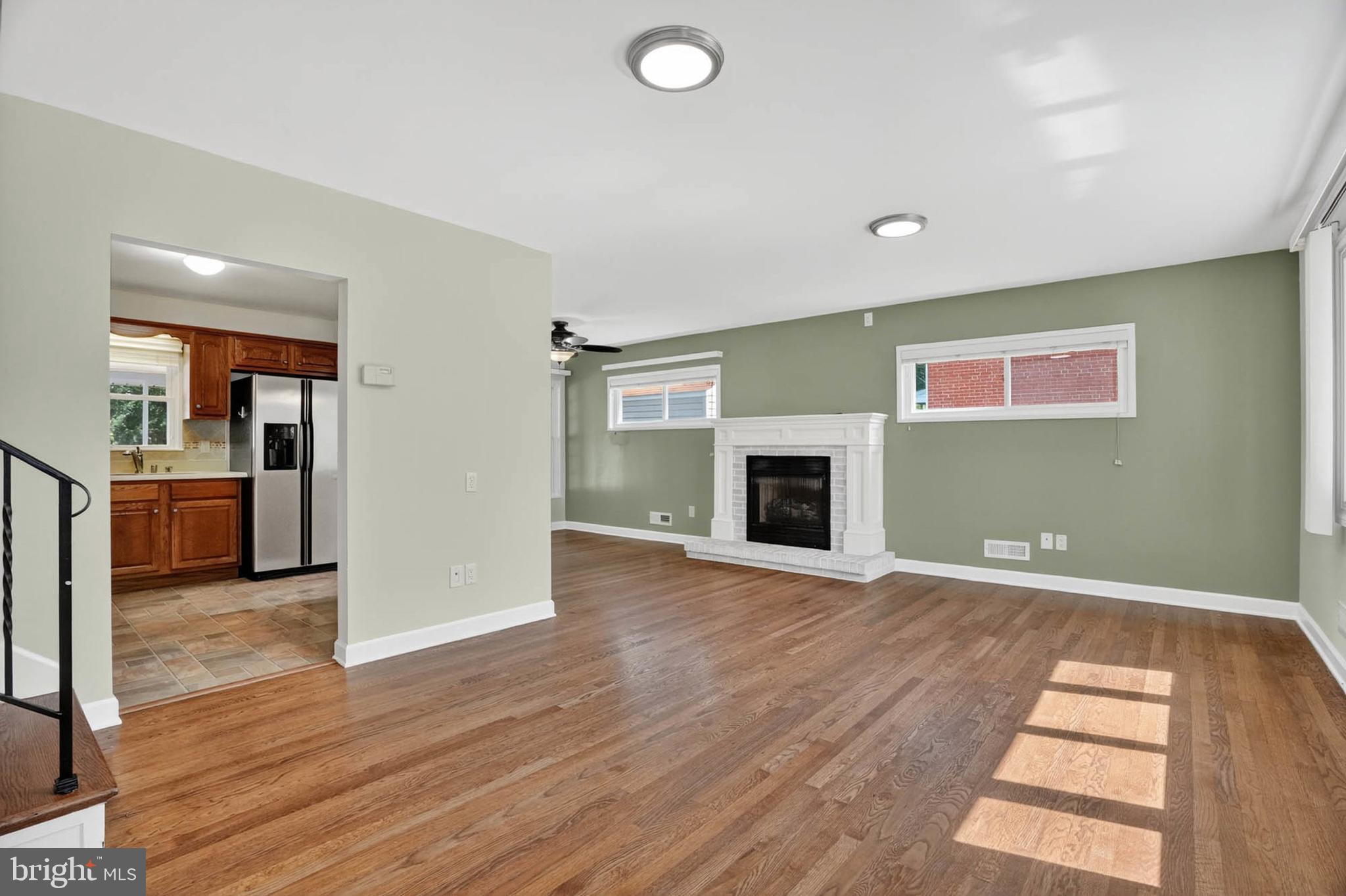 920 Vanderwood Road Catonsville, MD 21228 - Photo 3 of 25 an empty room with wooden floor and fireplace