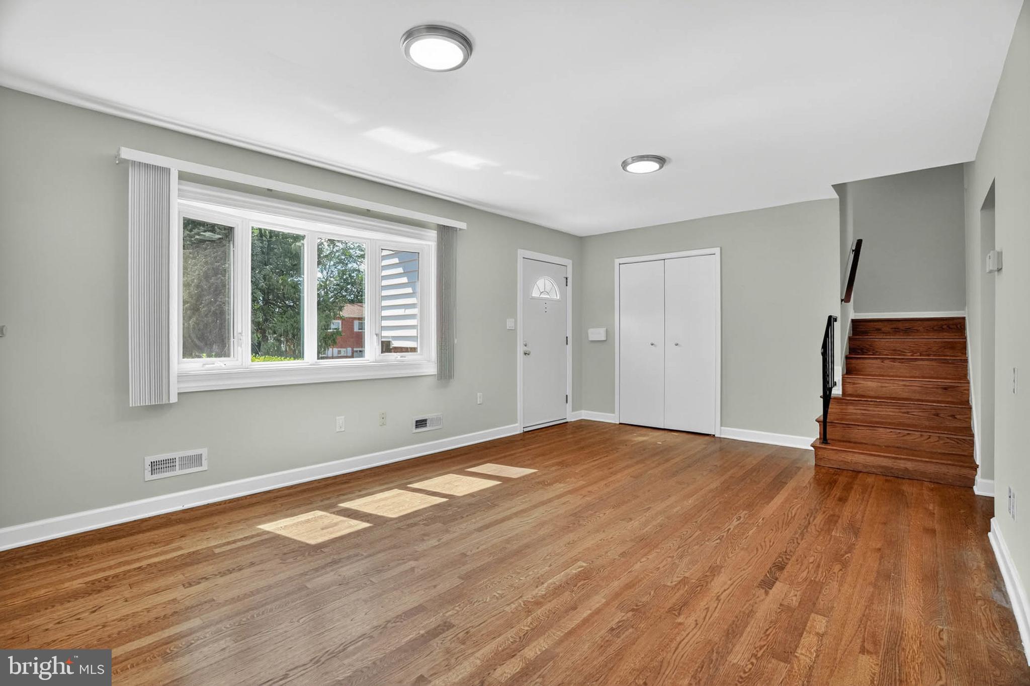 920 Vanderwood Road Catonsville, MD 21228 - Photo 5 of 25 a view of an empty room with wooden floor and a window