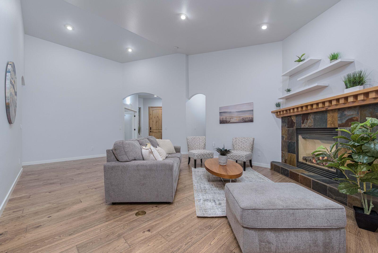19442 Chip Shot Lane Bend, OR 97702 - Photo 12 of 47 Great room with beautiful engineered wood floors and a cozy gas fireplace. The home lives like a single level with two ensuites and an office all on the main floor.