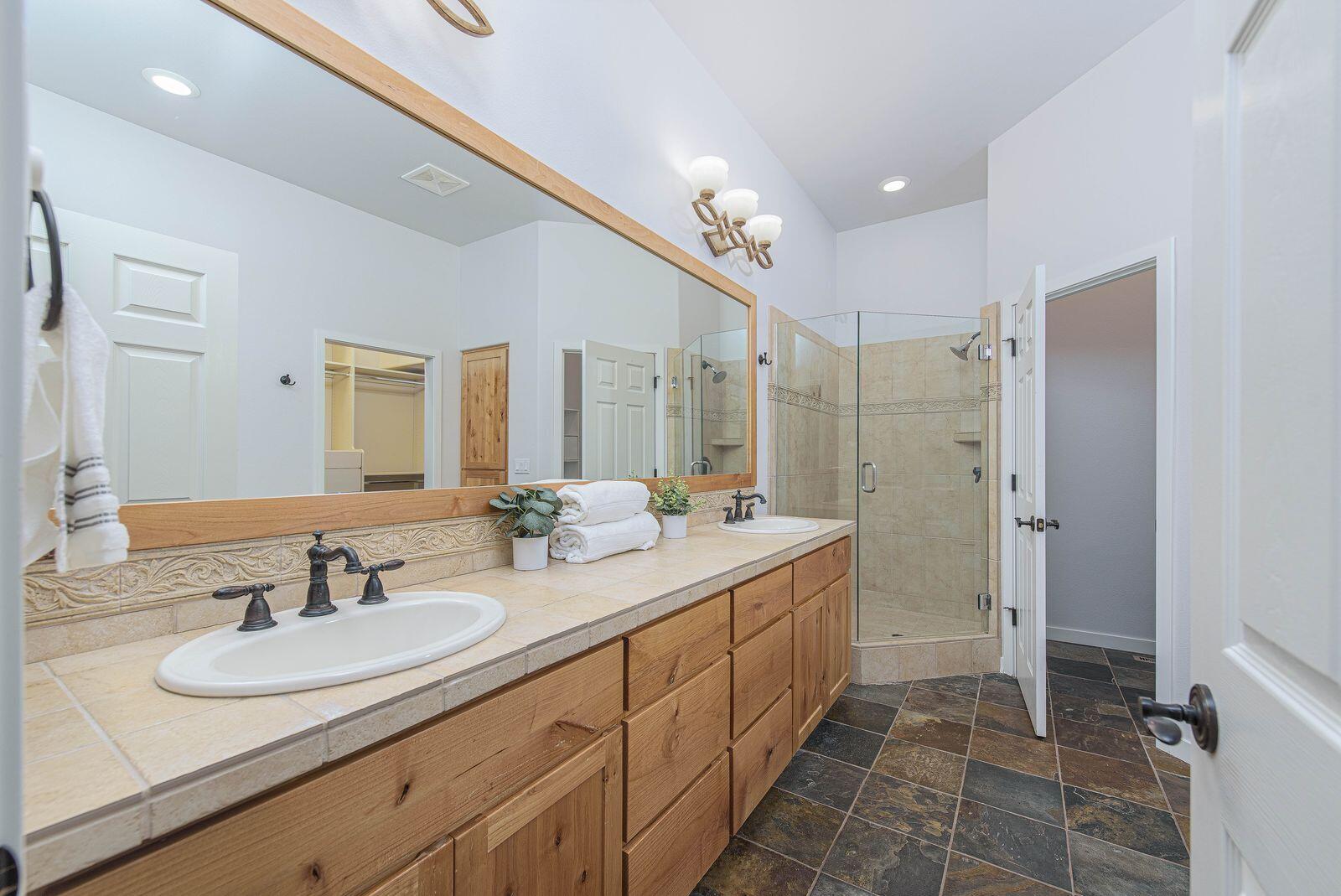 19442 Chip Shot Lane Bend, OR 97702 - Photo 22 of 47 Primary bathroom with dual sinks, walk in shower, and lots of cabinetry