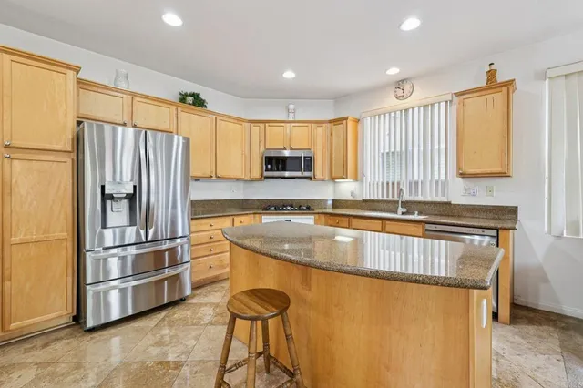 a open kitchen with granite countertop a sink a counter top space and living room