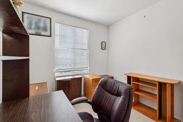 a view of a workspace with furniture and a window