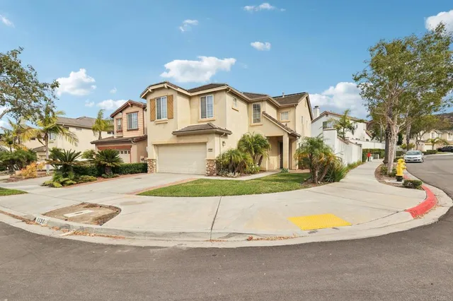 a view of a white house with a yard and sitting area
