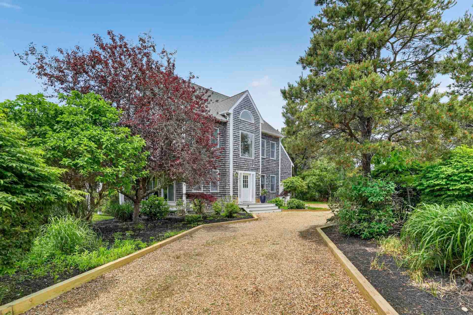 9 Thaxter Lane Edgartown, MA 02539 - Photo 3 of 53 a view of a brick house with a yard and large trees