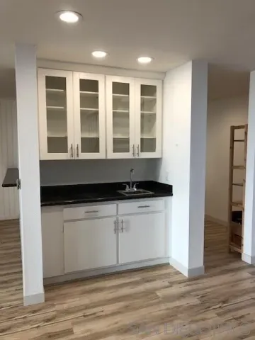 a view of granite countertop a sink and dishwasher with wooden floor