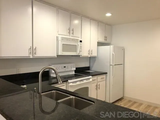 a kitchen with appliances a sink and cabinets