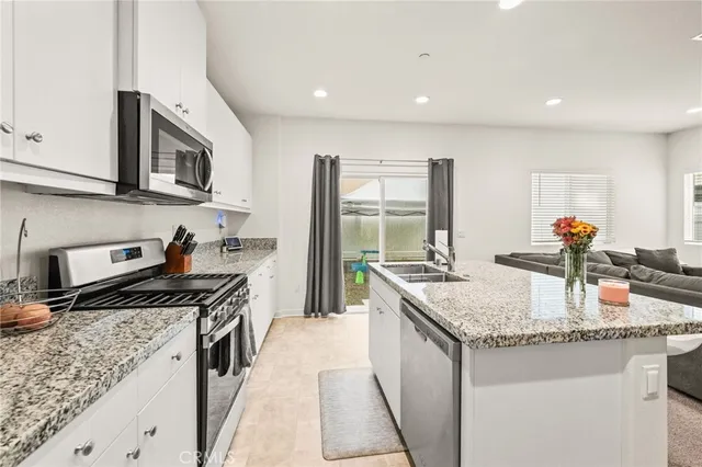 a kitchen with stainless steel appliances granite countertop a sink stove and cabinets