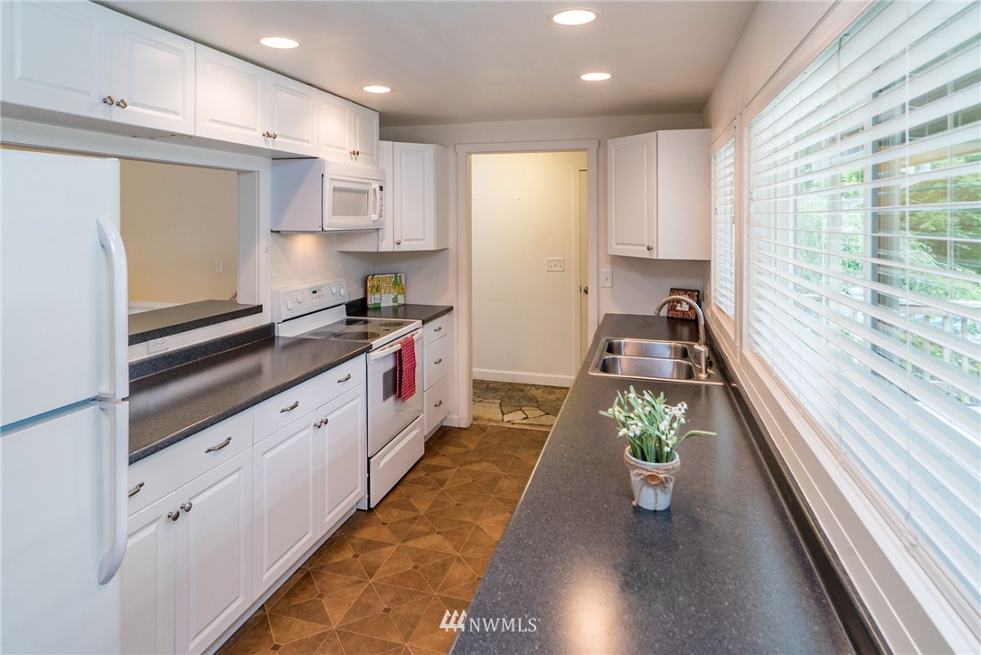 10215 Northeast 198th Street Bothell, WA 98011 - Photo 5 of 25 a kitchen with kitchen island granite countertop lots of counter top space and wooden floor