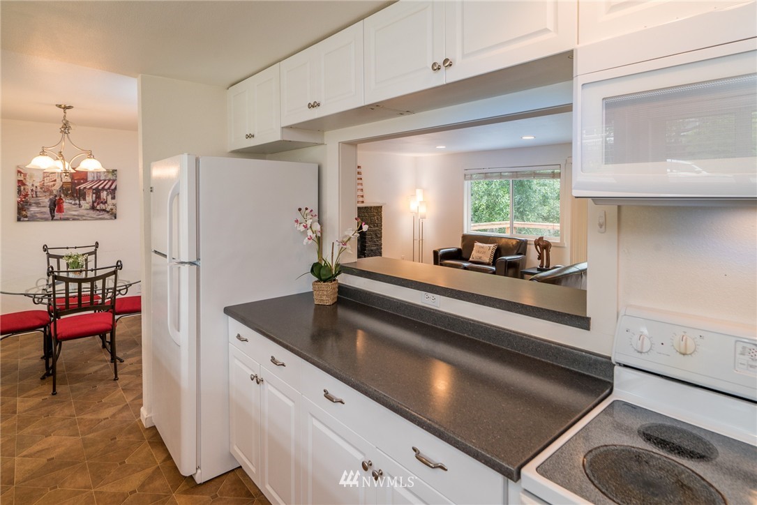 10215 Northeast 198th Street Bothell, WA 98011 - Photo 6 of 25 a kitchen with kitchen island a counter top space a sink a refrigerator and a window
