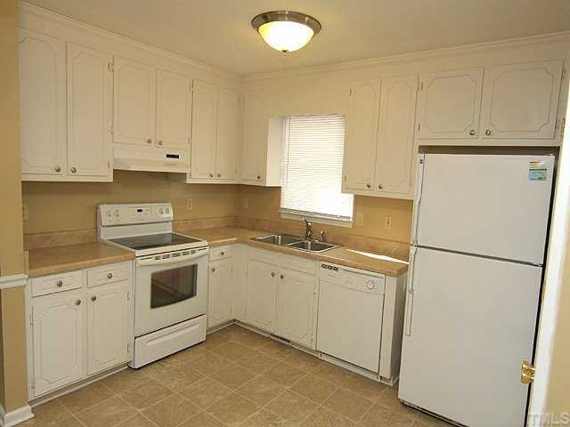 4125 Timberbrook Drive Raleigh, NC 27616 - Photo 5 of 12 a kitchen with a sink a stove a refrigerator and white cabinets