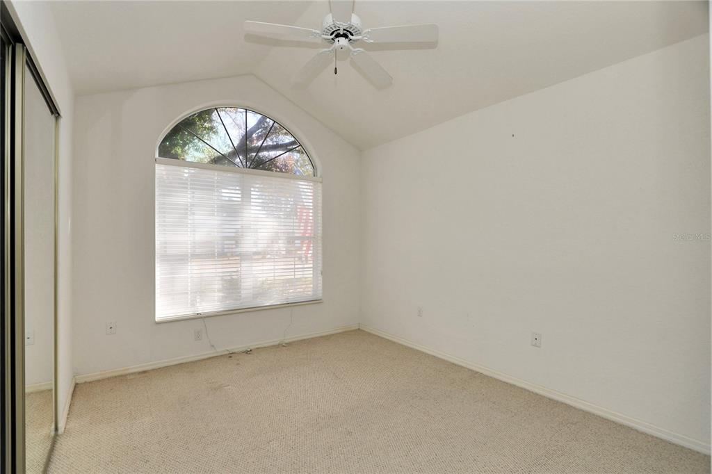 8319 Southwest 108th Loop Ocala, FL 34481 - Photo 17 of 27 an empty room with a large window wooden floor and a ceiling fan