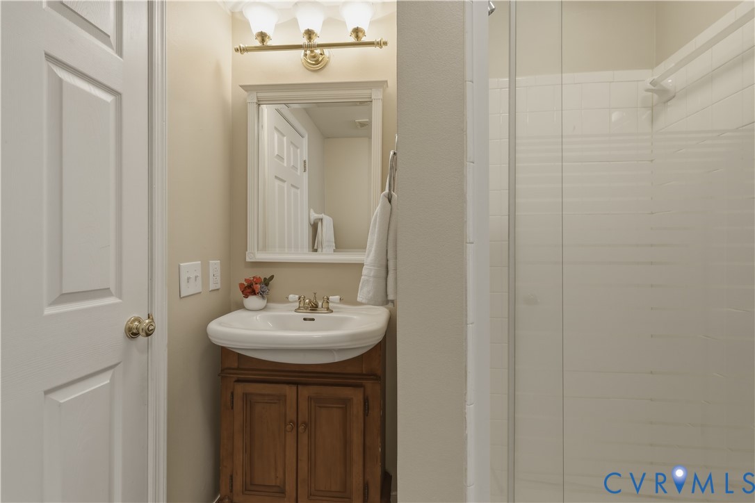 301 Beacon Ridge Drive, Unit 109 Hopewell, VA 23860 - Photo 17 of 30 a bathroom with a sink a mirror and a shower