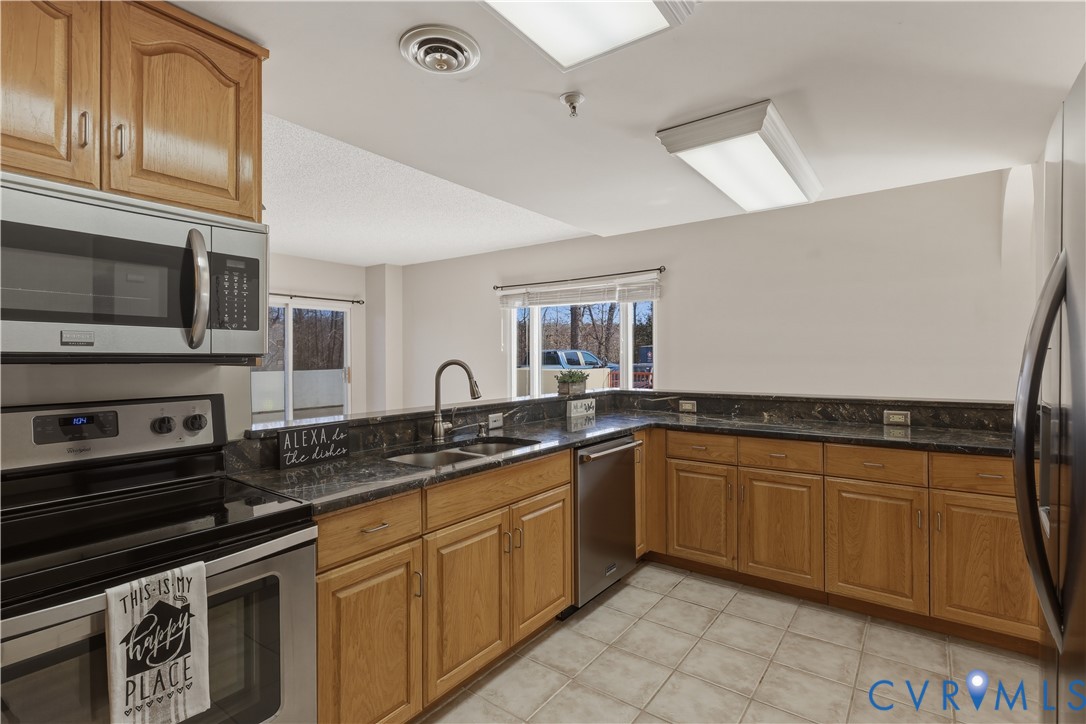 301 Beacon Ridge Drive, Unit 109 Hopewell, VA 23860 - Photo 7 of 30 a kitchen with stainless steel appliances granite countertop a sink and stove top oven