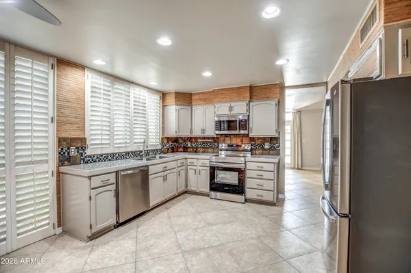 a kitchen with stainless steel appliances a refrigerator sink and cabinets