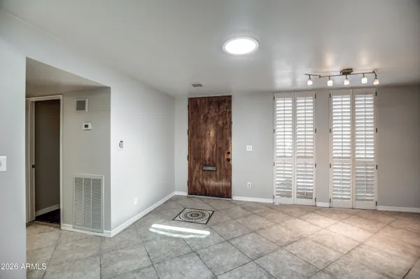 a view of an empty room with a fireplace and a chandelier