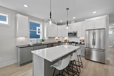 a kitchen with stainless steel appliances granite countertop a sink a stove and a refrigerator