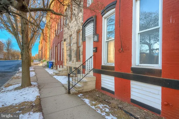 a view of a building with large tree and wooden fence
