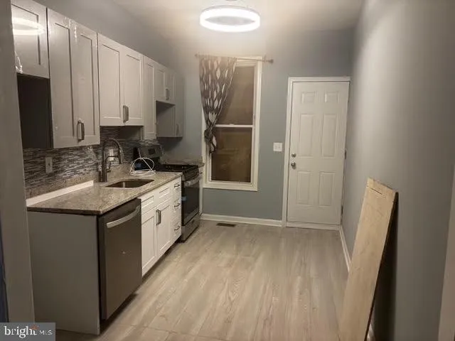 a kitchen with a sink a refrigerator and a window