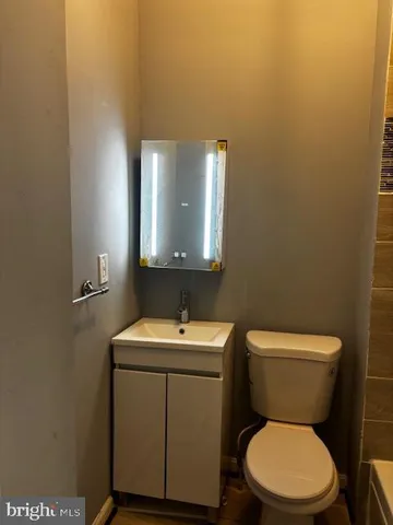 a bathroom with a toilet a sink and mirror