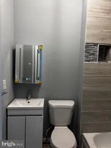 a bathroom with a toilet sink and mirror