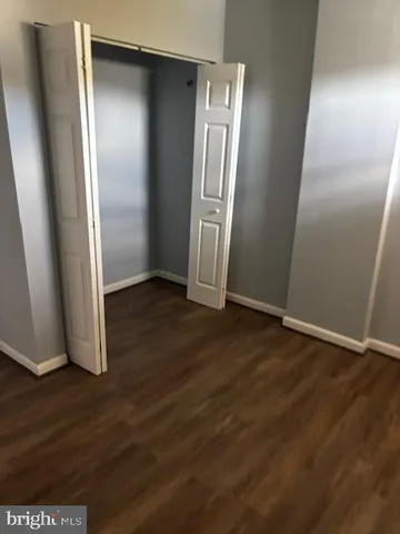 an empty room with wooden floor and closet
