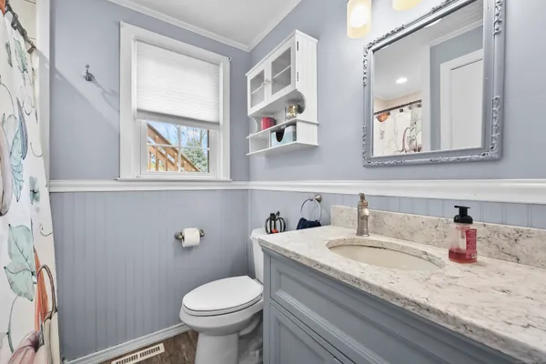 a bathroom with a granite countertop toilet sink and mirror