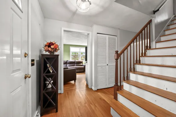 a view of a hallway with wooden floor and stairs