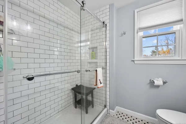 a bathroom with a toilet and a shower