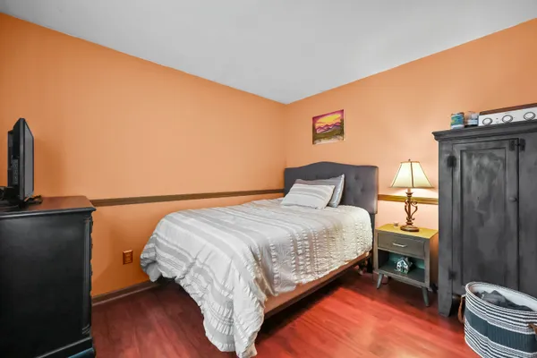 a bed sitting in a bedroom next to a window with wooden floor