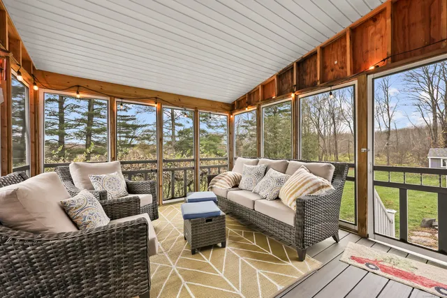 a living room with furniture tv and large windows