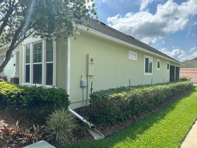 a front view of a house with a garden and trees