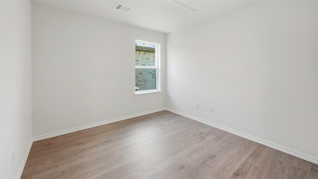 312 Wild Rose Way Princeton, TX 75407 - Photo 37 of 39 an empty room with wooden floor and windows
