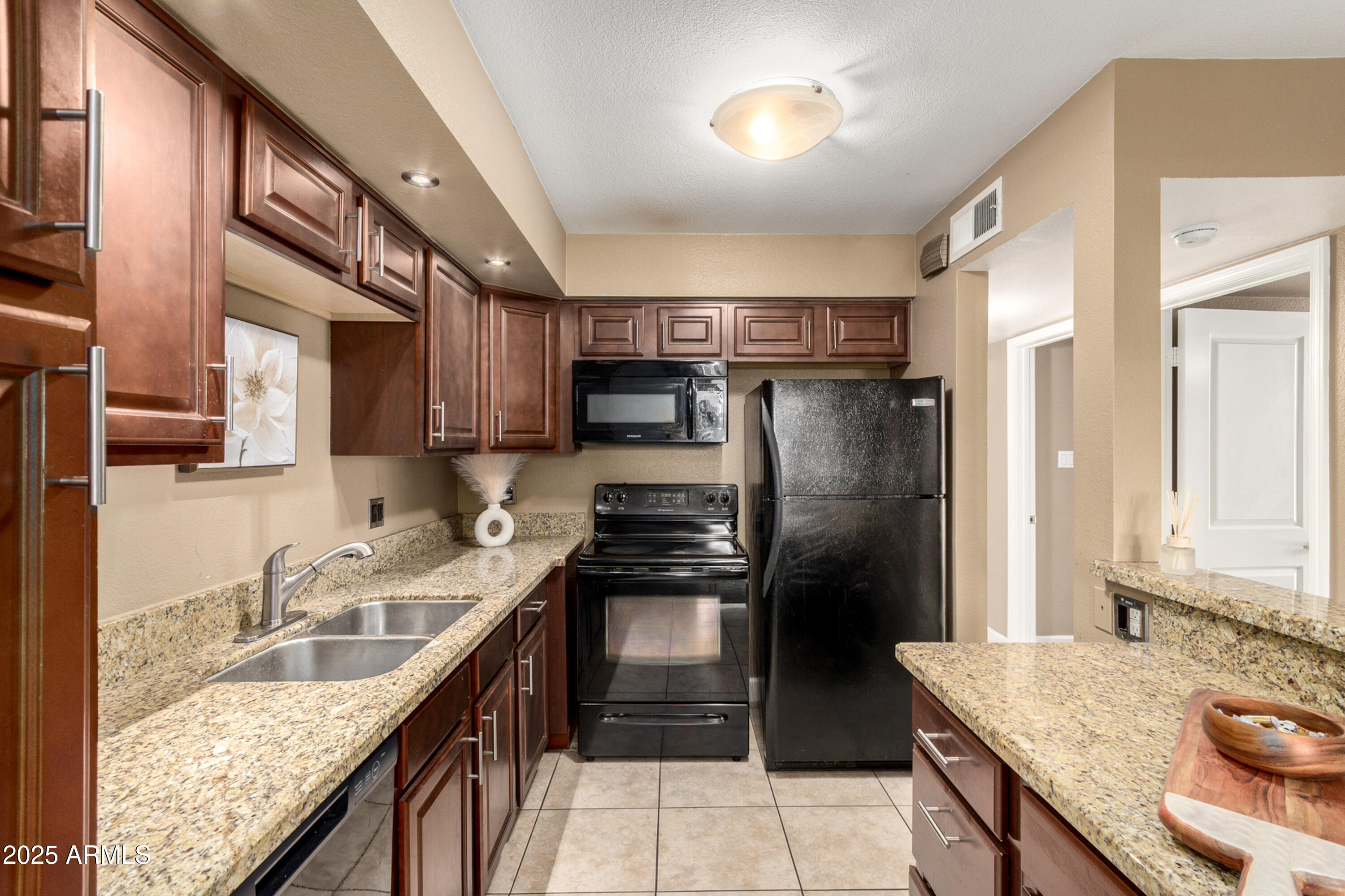 1241 East Medlock Drive, Unit 113 Phoenix, AZ 85014 - Photo 11 of 24 a kitchen with kitchen island granite countertop a sink stove and refrigerator