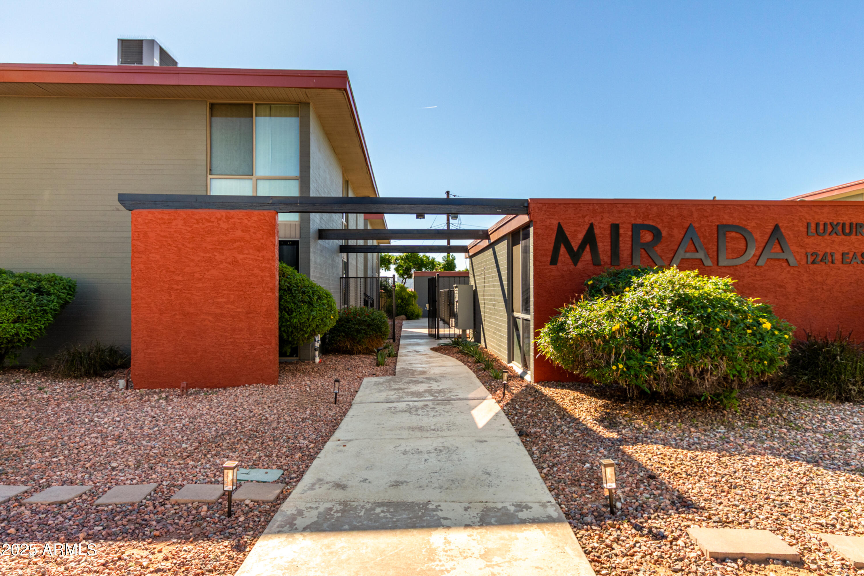 1241 East Medlock Drive, Unit 113 Phoenix, AZ 85014 - Photo 2 of 24 a front view of a house with a yard and potted plants