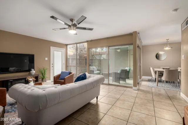 a living room with furniture and a flat screen tv with kitchen view