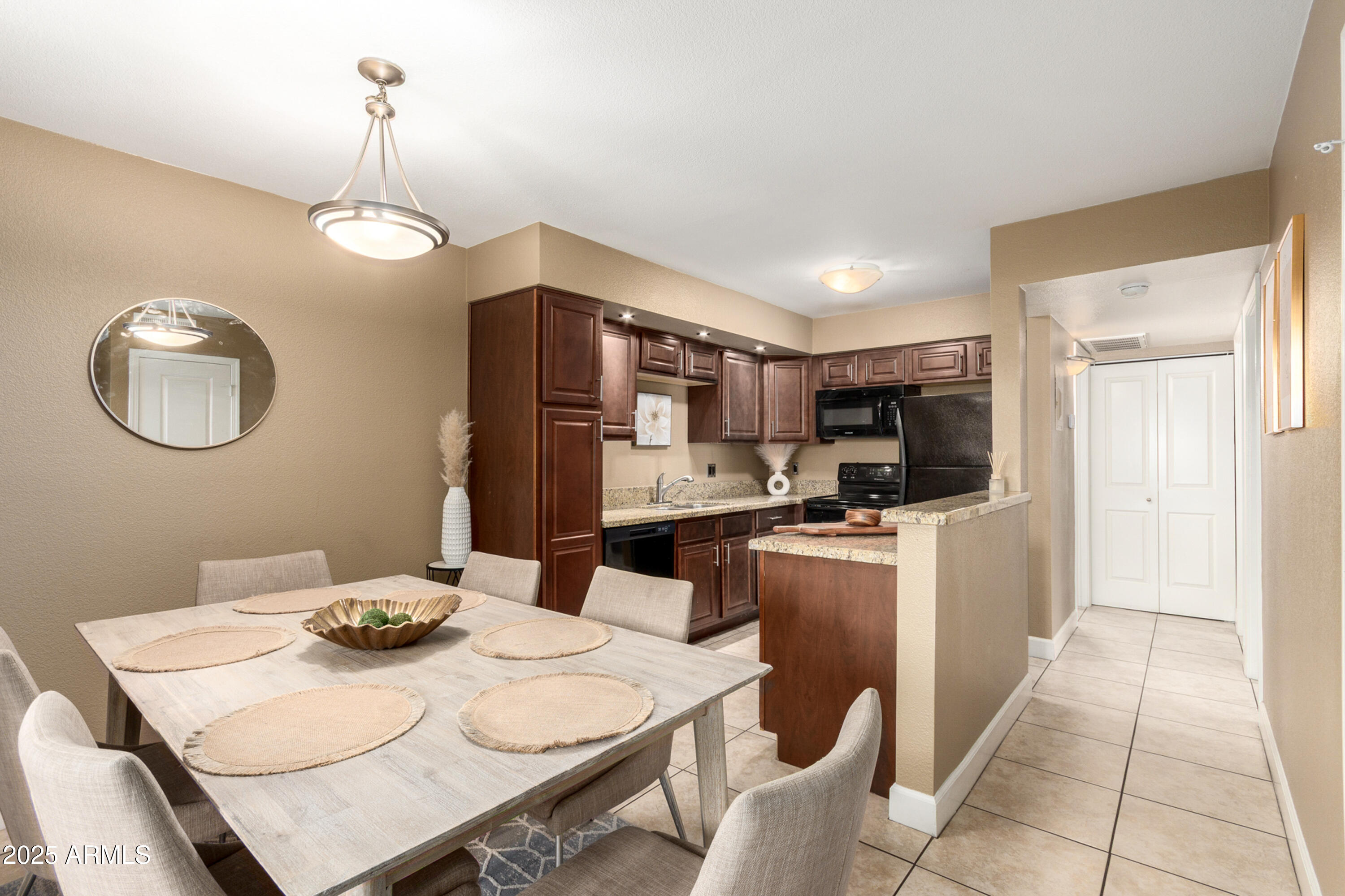 1241 East Medlock Drive, Unit 113 Phoenix, AZ 85014 - Photo 7 of 24 a kitchen with stainless steel appliances granite countertop a sink dishwasher a stove a refrigerator a microwave oven with a dining table and chairs