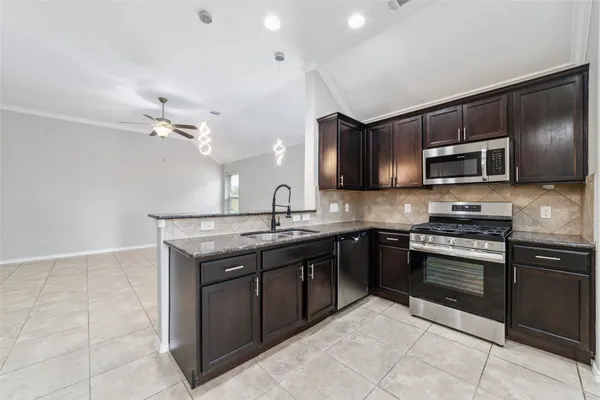 a kitchen with stainless steel appliances granite countertop a stove cabinets and microwave