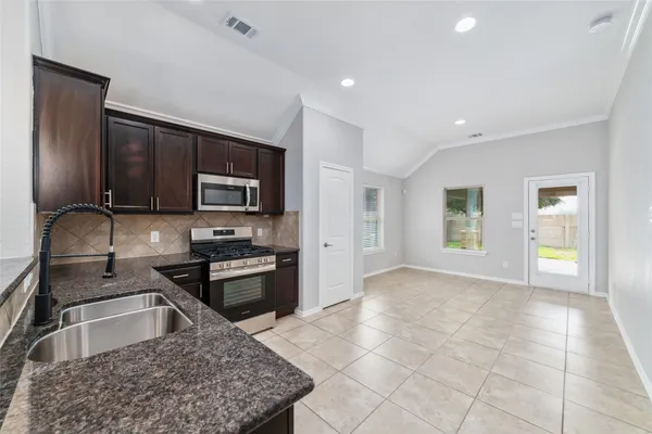 a kitchen with stainless steel appliances granite countertop a sink stove and refrigerator