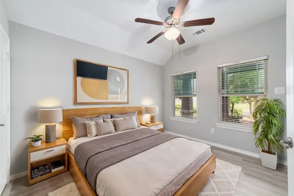 a bedroom with a bed ceiling fan and a window