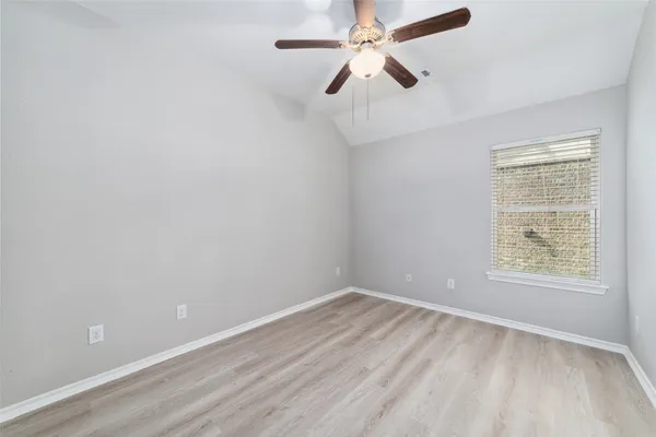 an empty room with a window and a fan