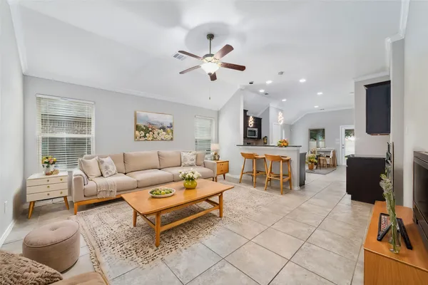 a living room with furniture and a view of kitchen